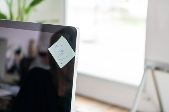 A computer monitor with a sticky note that says 'Good Job!' in an office.