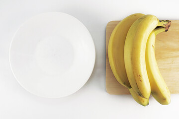 Bunch of banana on a cutting wooden with white plate © Yudy Pirmansah
