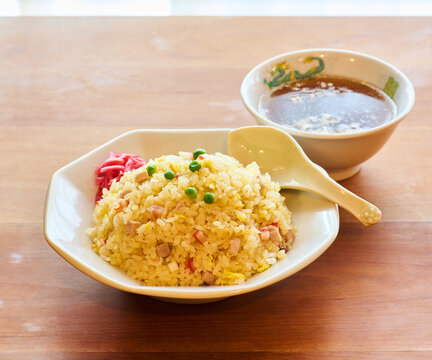 Japanese style fried rice chahan with green peas and pickled ginger on wooden table