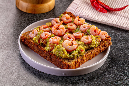 Avocado toast with shrimp on dark rye bread