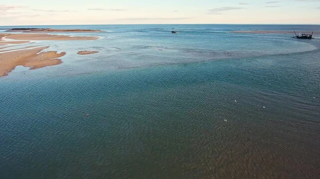 Aerial view of a dredging boat extracting sand from the seabed in the beautiful ria formosa lagoon, a crucial process for maintaining navigable channels and nourishing nearby beaches in algarve