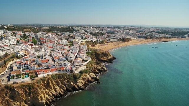 Beautiful aerial panorama showing the historic city of albufeira built on a cliff overlooking the turquoise waters of the atlantic ocean and the sandy praia dos pescadores in algarve, portugal