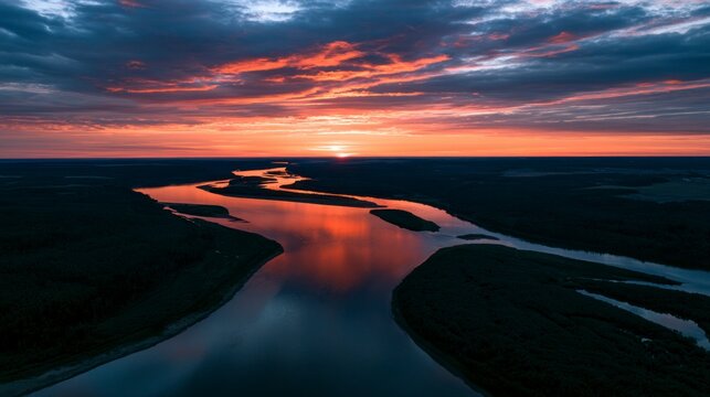 Aerial View of a Winding River at Sunset with Vibrant Orange Sky and Water Reflections