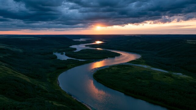 Aerial View of a Winding River Meandering Through a Lush Landscape at Sunset under Dramatic Stormy Clouds