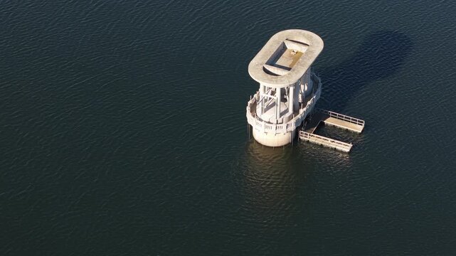 Silvan, Victoria, Australia - 01 September 2026: Aerial view of the concrete intake tower at Silvan Reservoir Park surrounded by calm deep water.