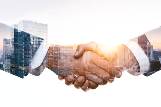 Close-up business handshake blended with a metropolitan skyline at sunrise, representing professional partnership, corporate deal, investment, trust and business expansion