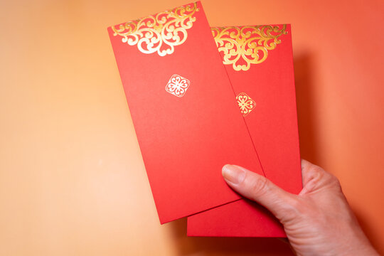 Hand Holding Traditional Chinese Red Envelopes for New Year