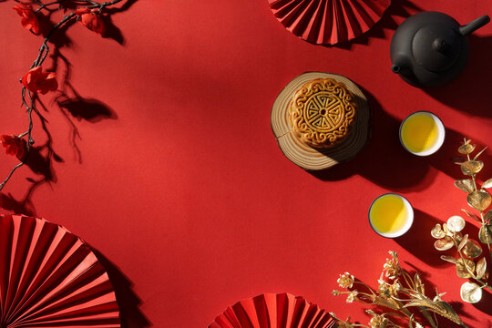 Mid Autumn Festival mooncake with tea on red background for holiday celebration