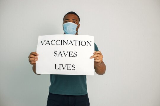 Black guy holding a poster with words vaccination saves lives