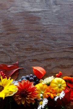 Autumn flat lay. Colorful pumpkins, autumn leaves, flowers border on rustic wooden table. Happy Thanksgiving. Fall season greeting card, space for text