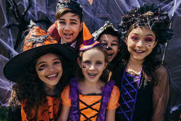 Naklejka premium Little adorable children in creative Halloween costumes enjoying a fun trick or treat celebration