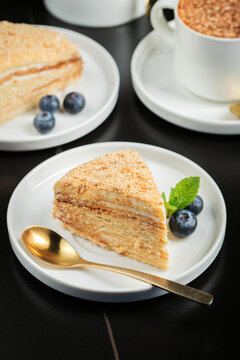 Medovik. Honey cake made from honey cakes with whipped sour cream, decorated with berries, pomegranate and flowers