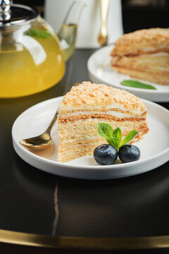 Medovik. Honey cake made from honey cakes with whipped sour cream, decorated with berries, pomegranate and flowers