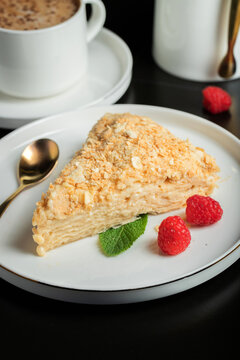 Sliced Napoleon cake on a white wooden table. Classic dessert