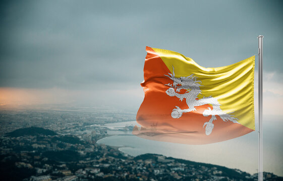 Bhutan flag waving over a coastal city under dramatic cloudy sky, realistic fabric motion, aerial seaside landscape background. Bhutan national flag for independence day.