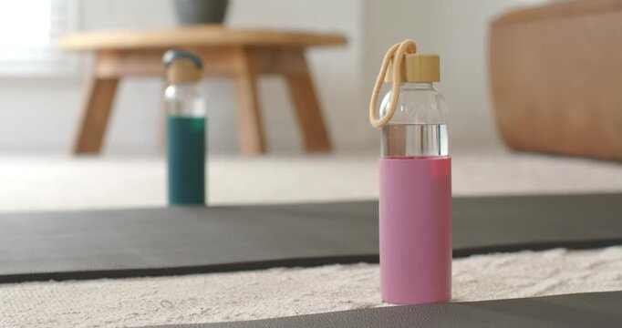 Autofocus is sharpening pink water bottle on yoga mat under soft natural light to highlight design
