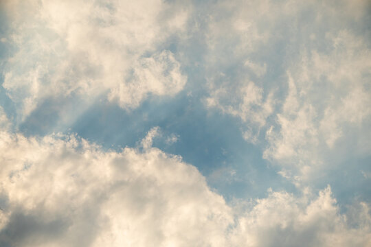 White cumulus clouds clustered against a backdrop of partial blue sky, with soft sunlight breaking through. The sky was cloudy, yet it brought no questions or messages with it. 