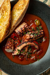 Delicious octopus stew served with crispy toasted bread in a vibrant setting © Tkachenko Alexey