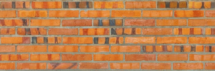 Fototapeta premium Orange brick wall constructing a textured background with varying earthy tones