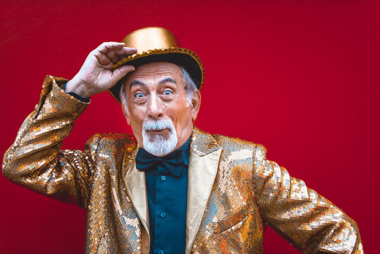 Eccentric senior man portrait - cool and modern old man wearing colorful stylish clothing on colored background
