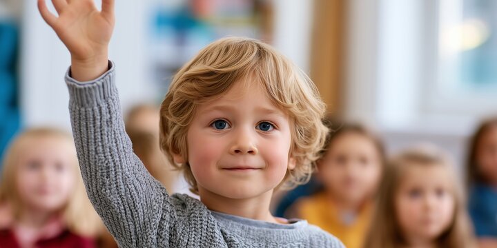 Cheerful pupil raises a hand eagerly in a bright classroom. Confidence, participation and enthusiasm for learning during an everyday lesson.