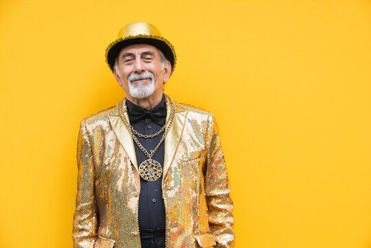 Eccentric senior man portrait - cool and modern old man wearing colorful stylish clothing on colored background