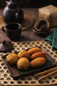 Indonesian traditional fritters known as Combro and Misro made from grated cassava, served on a ceramic plate. Combro are round-shaped savory fritters stuffed with spicy oncom (ferme