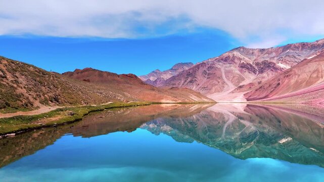 Cinematic Drone Shot of the Stunning Blue Waters of Chandratal Lake in Spiti Valley, Himachal Pradesh Surrounded by Rugged Rocky Himalayan Mountains on a Sunny Day