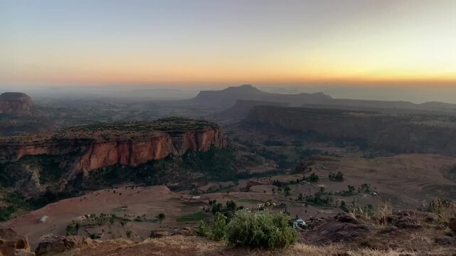 View of the rugged Ethiopian highlands with dramatic cliffs and plateaus illuminated by the warm light of the setting sun, Ethiopia.