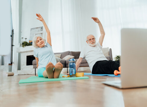 Elderly couple doing fitness training together at home 