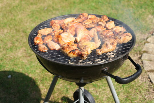 Meat skewers cooking over hot charcoal on an outdoor barbecue