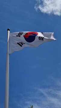 Flag of the Republic of Korea against a clear blue sky. National Korean symbol of freedom and unity. South Korean national flag fluttering on a high flagpole on a sunny day. Concept of patriotism