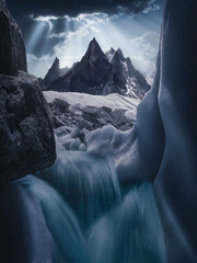 Dramatic glacial ice formations frame rugged mountain peaks, creating a cold surreal wilderness scene ideal for adventure travel, climate, geology and environmental campaigns. © UQink