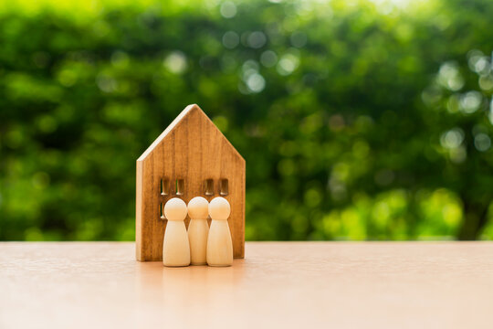 House and wooden figures on a table, family concept and protection and insurance.
