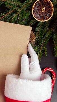 Santa Claus hand in white glove holding empty craft paper. Blank scroll parchment. Festive layout. Christmas copy space background. Santa wishlist tutorials. Festive eco friendly layouts