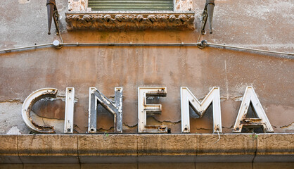 Weathered vintage cinema sign on old building facade in Verona, Italy © S J Lievano