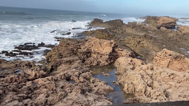 Waves crashing against the rocky coast below the fortress of Essaouira in Morocco, Africa