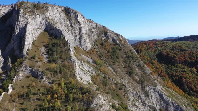 Aerial rocky alpine mountain landscape, white limestone cliffs autumn forest by drone