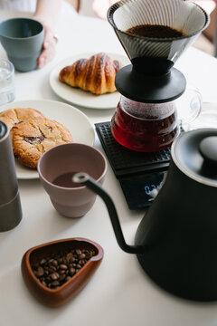 Morning Pour Over Coffee Ritual with V60 Dripper and Freshly Brewed Specialty Coffee Served with Croissant and Cookies at Home. vertical composition
