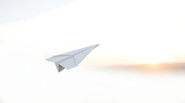 White paper airplane gliding through the air toward a bright sunset horizon with white plane