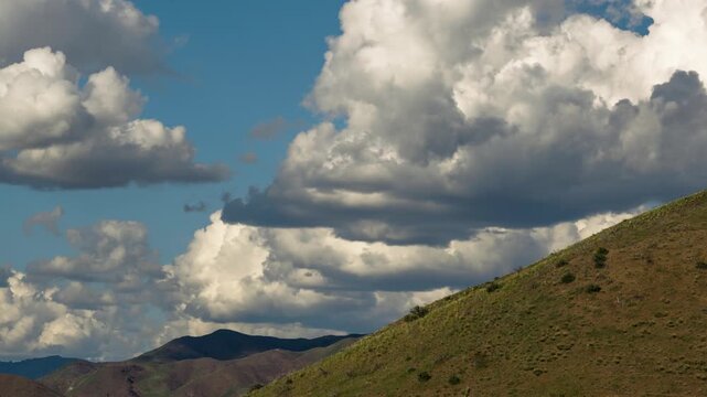 View of the rolling hills and dramatic clouds over Lucky Peak Lake in Ada County, Idaho, United States.