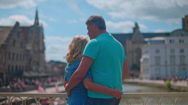 Embracing on a bridge with a view of the old town