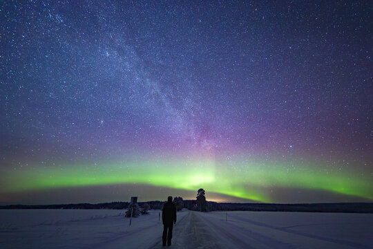 Person Watching the Milky Way and Northern Lights in Winter