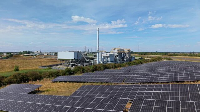 Aerial view of biomass energy recovery power plant and solar panel array in rural UK