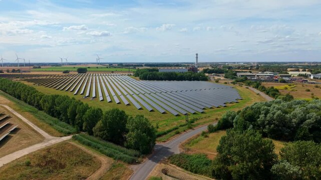 Aerial panning shot contrasting modern green solar farm with gas turbine power station Sutton Bridge UK