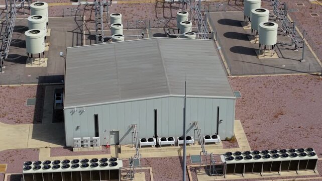 Close up aerial view of rotating cooling fans on high voltage transformer at wind farm substation UK