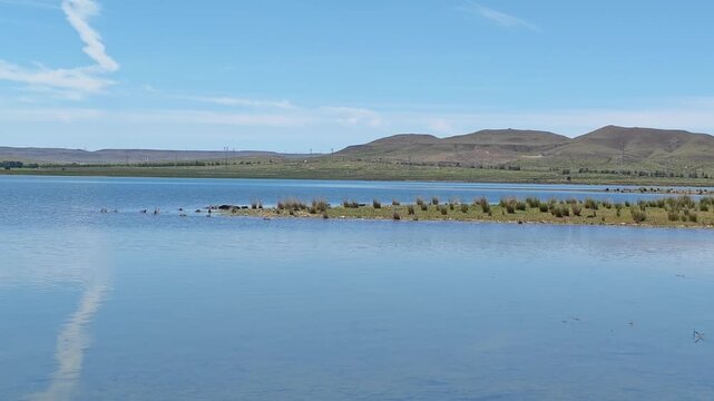 Scenic landscape of salt lake wetland and distant wind turbines in summer in Ulan Hada Volcano Geopark, Ulanqab, Inner Mongolia, China