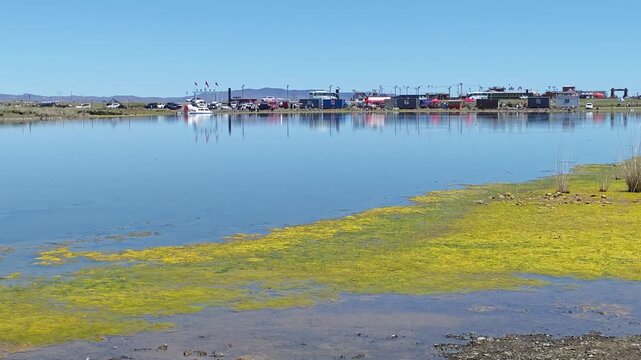 Scenic landscape of salt lake wetland and distant wind turbines in summer in Ulan Hada Volcano Geopark, Ulanqab, Inner Mongolia, China