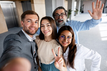 Obraz premium Happy diverse business team taking office selfie