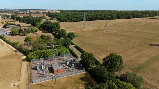 Close up aerial view of high voltage step down transformers and cooling radiators at electrical substation in the UK